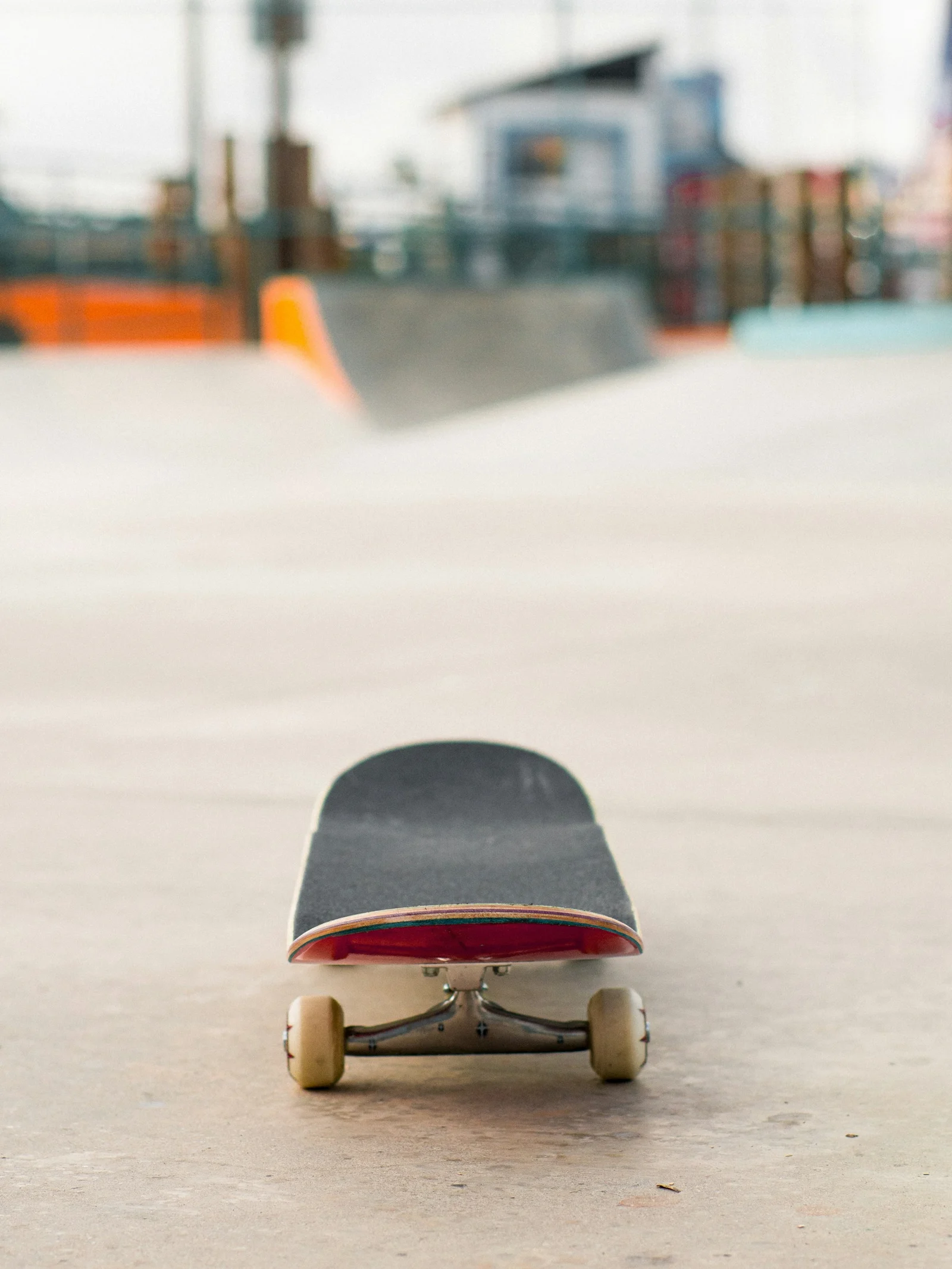 A skateboard sits in front of a skate park.；第三方摄影参考