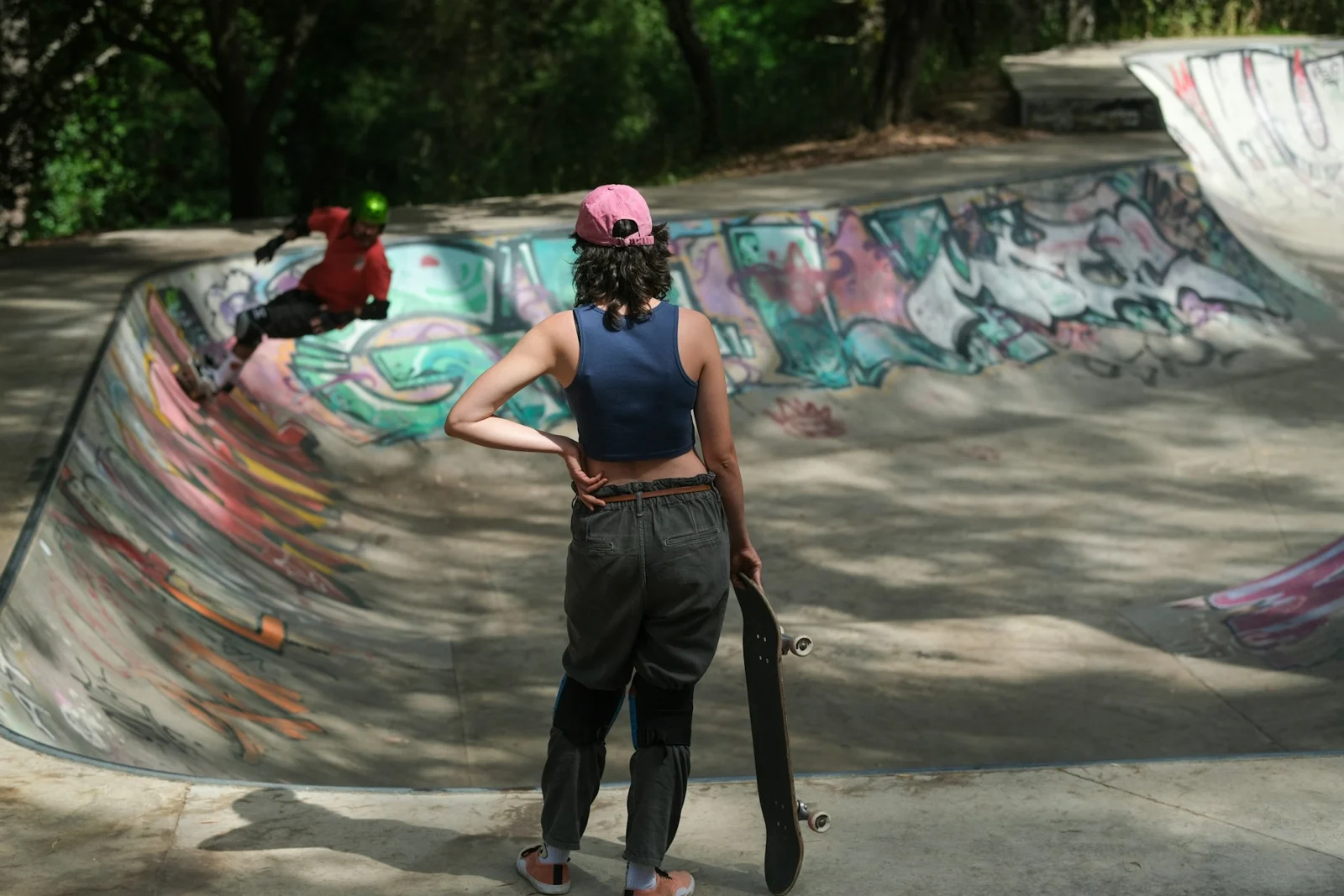A person holding a skateboard at a skate park;第三方摄影参考