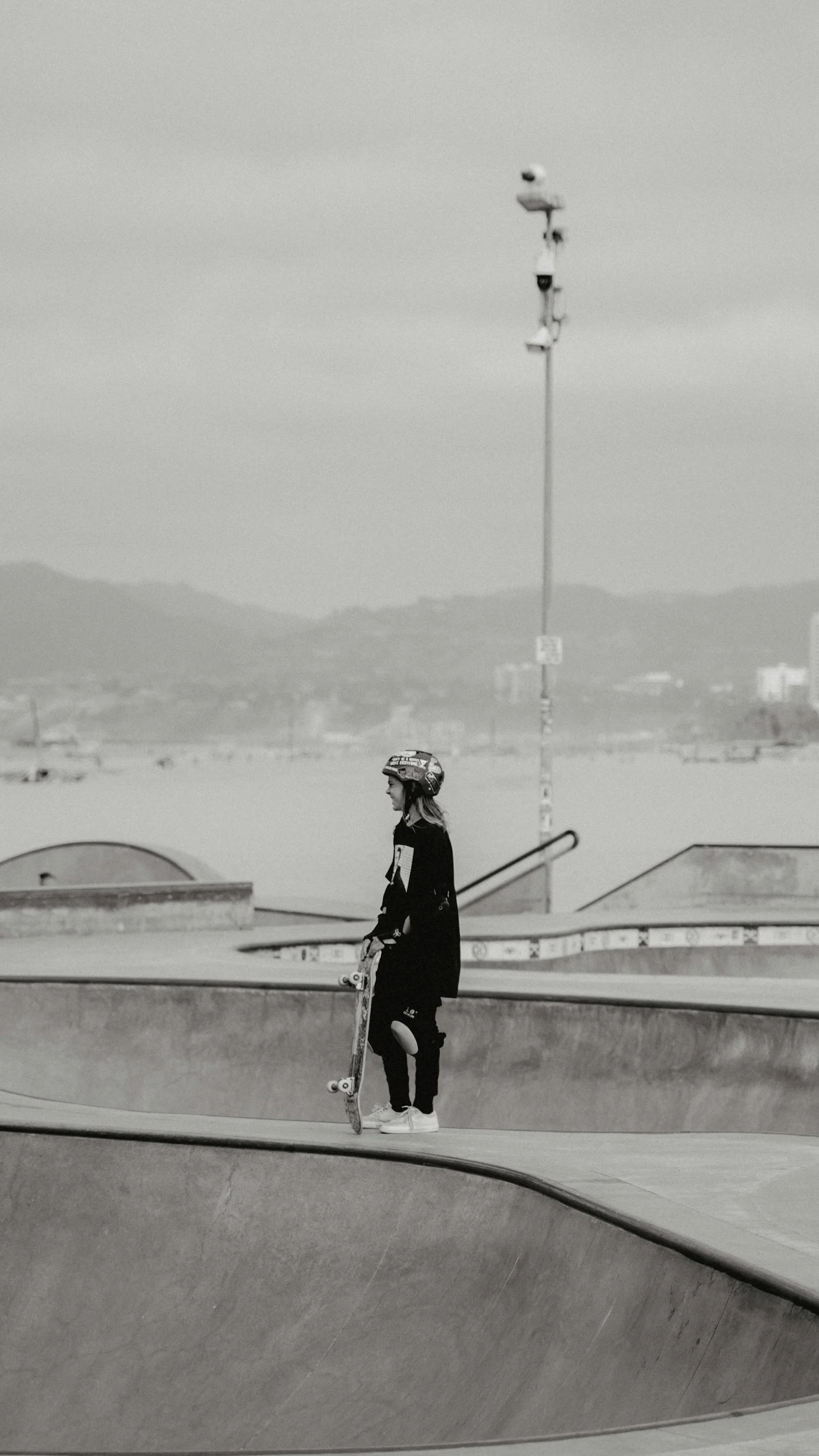 Skateboarder in helmet at skatepark by the water；第三方摄影参考